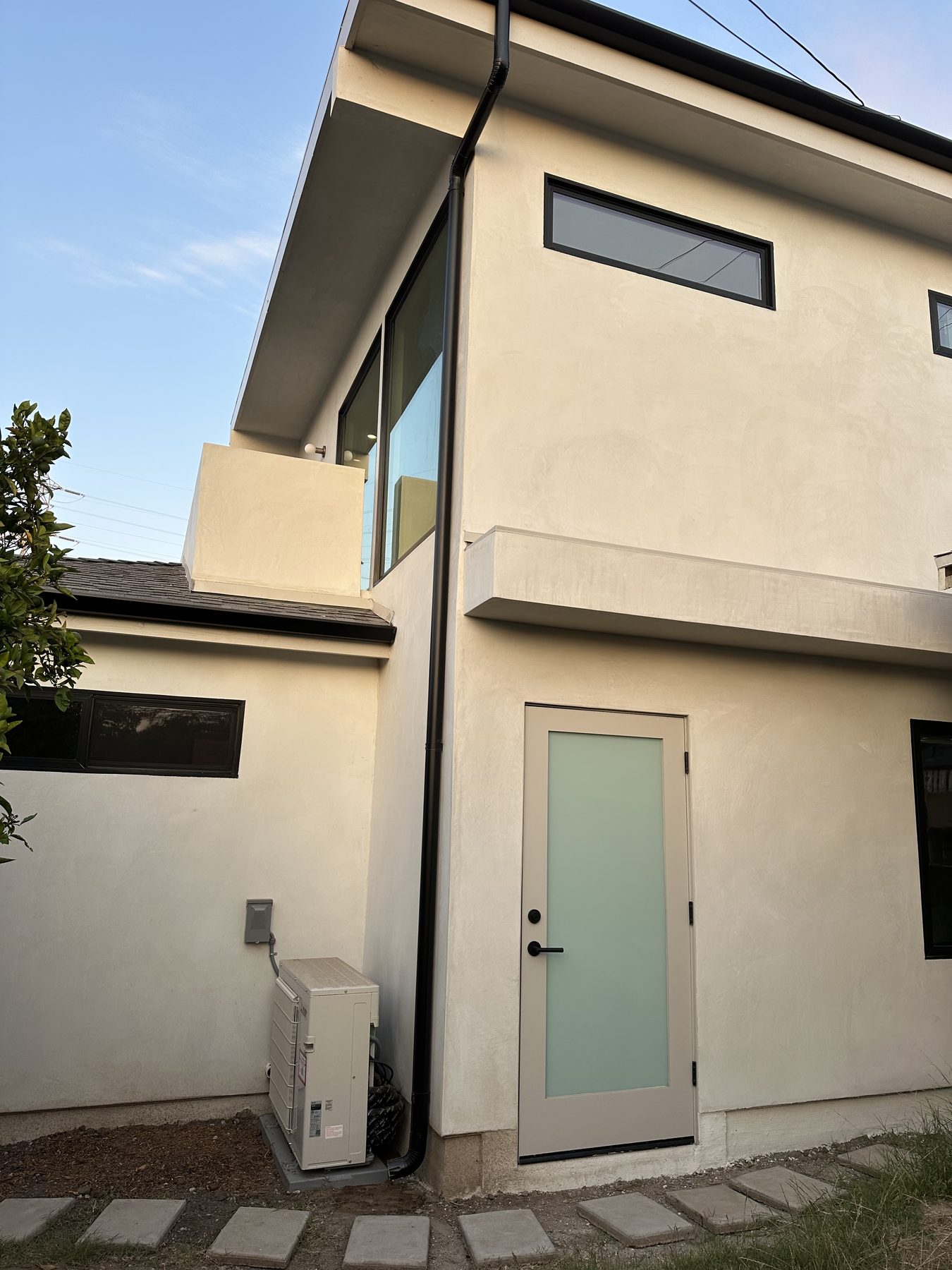 Completed two-story ADU exterior with clerestory windows and entry door