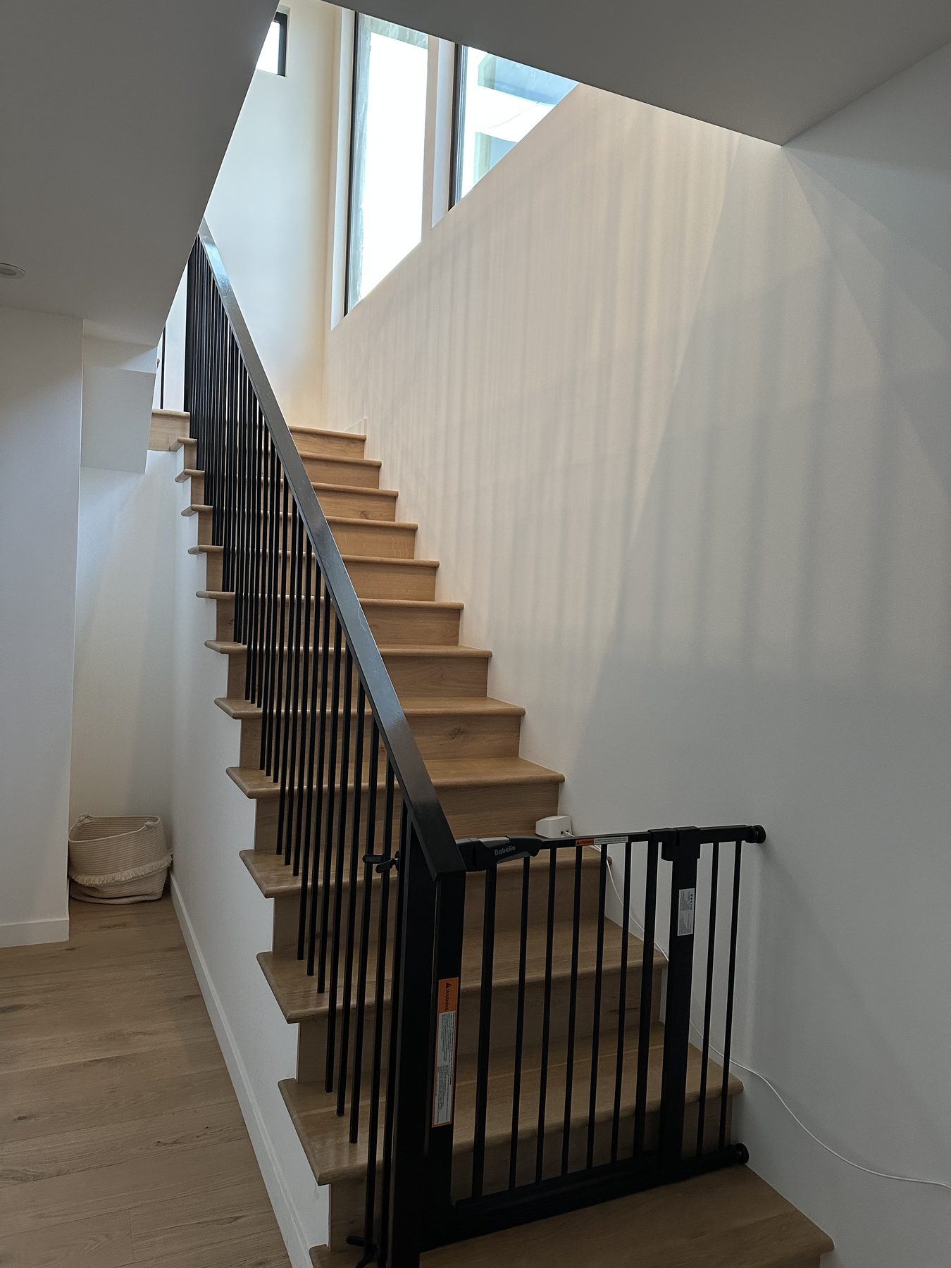 Completed ADU stair with black metal railing and wood treads